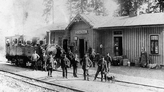 Historische Aufnahme von Menschen und einer Lokomitive im Bahnhof Schierke