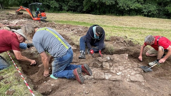 Archäologen graben ein altes Steinfundament aus