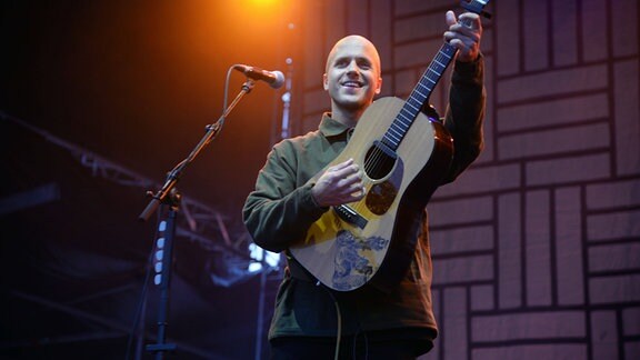 Milow, eigentlich Jonathan Ivo Gilles Vandenbroeck, ein belgischer Singer-Songwriter, mit Gitarre auf der Bühne
