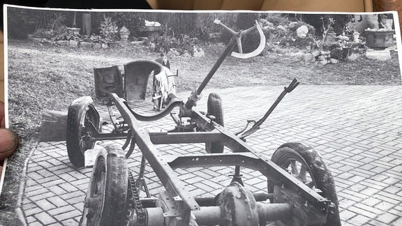 Schwarz-weiß-Foto eines alten Fahrwerks mit einem platten Reifen. Es gehört zu einem "Sperber"