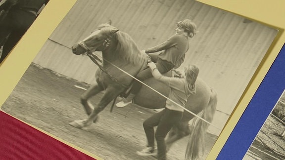 Schwarz-weiß Bild auf dem zwei Kinder auf einem Pferd reiten