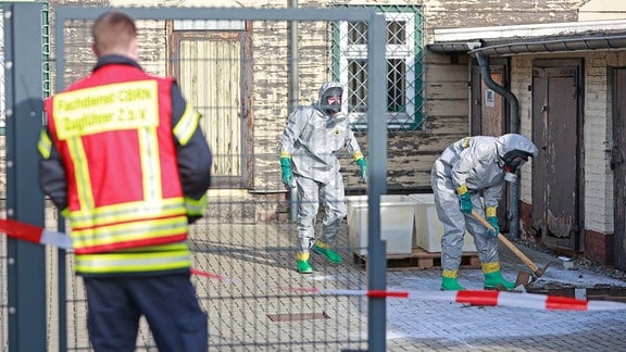 Einsatzkräfte der Feuerwehr im ABC-Schutzanzug beseitigen kontaminierten Boden auf dem Gelände der Harzer Schmalspurbahnen GmbH in Wernigerode.