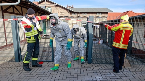 Einsatzkräfte der Feuerwehr im ABC-Schutzanzug beseitigen kontaminierten Boden auf dem Gelände der Harzer Schmalspurbahnen GmbH in Wernigerode.