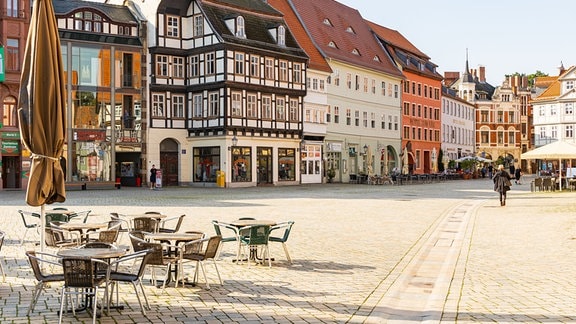 Auf dem Marktplatz von Quedlinburg stehen mehrere Tische und Stühle.
