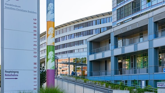 Neben dem Eingang des Harzklinikums Quedlinburg stehen eine bunte Säule und ein Hinweisschild. 