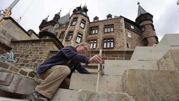 Konstanze Böhl, Steinmetzin von der Bauhütte Naumburg richtet die Stufen der neuen Freitreppe zur großen Terrasse im Schloss Wernigerode aus. 