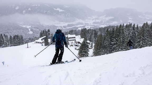 Ein Skifahrer ist auf einer Piste unterwegs