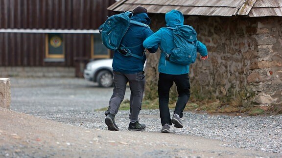 Wanderer haben Mühe sich bei dem Wind aufrecht zu halten.