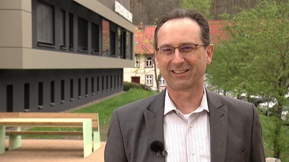 Ein Mann im Anzug wird vor der Hochschule Harz interviewt