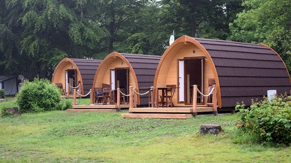Moderne, runde Holzhütten auf einem Campingplatz.