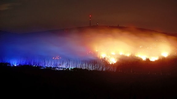 Blick auf Flammen und Glutnester am Königsberg im Harz unterhalb des Brockens.