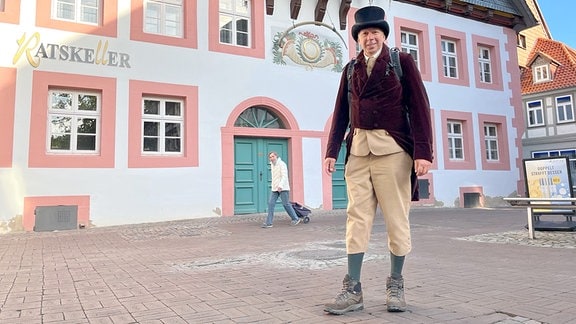 Der Wanderer Michael Lütje als Heinrich Heine vor einem historischen Gasthaus: "Ratskeller"