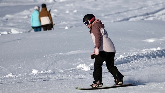 Eine Snowboarderin fährt am Wurmberg einen Abhang hinunter. Die Wintersportsaison im Harz hat begonnen.