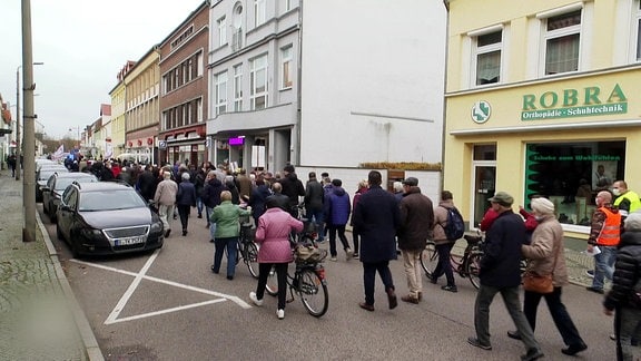Menschen laufen durch die Innenstadt von Genthin, um gegen die Schließung des Krankenhauses zu demonstrieren