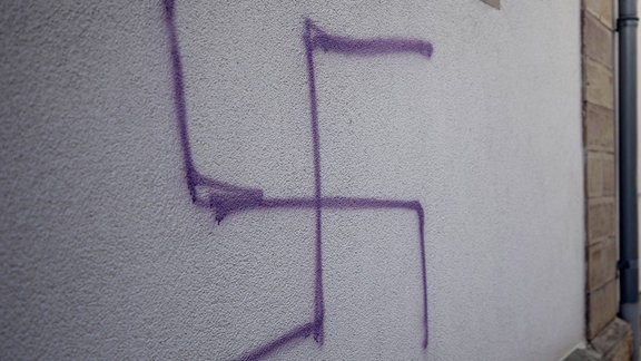 Hakenkreuze sind an die Wand einer ehemaligen Synagoge geschmiert.
