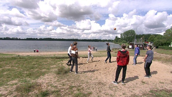 Jugendliche aus der Ukraine spielen Volleyball am Ufer des Barleber Sees