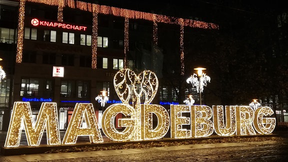  Ein riesiger, leuchtender Magdeburgschriftzug steht aus Lichterketten geform auf dem Bahnhofsvorplatz in Magdeburg.