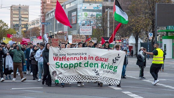Teilnehmer auf einer Pro-Palästina-Demonstration in Magdeburg mit einem großen Banner mit der Aufschrift "Waffenruhe in Gaza, stoppt den Krieg".