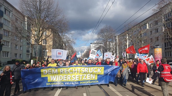 Ein Demonstrationszug läuft durch Magdeburg. Ganz vorne tragen die Menschen ein Banner, auf dem "Dem Rechtsruck widersetzen" zu lesen ist.