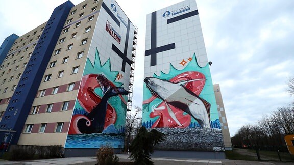 Graffiti mit dem Titel "Die wachsame Walerie" an zwei Plattenbauten