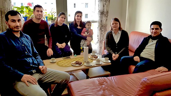 Die ehrenamtliche Integrationslotsin Brigitte Kaiser-Kovacs sitzt bei einer Familie, die sie betreut, auf dem Sofa