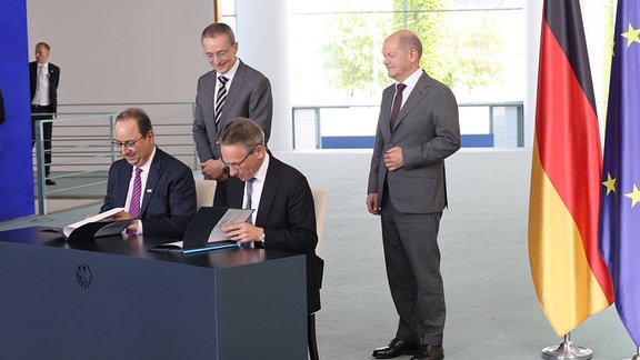 Bundeskanzler Olaf Scholz und CEO von Intel, Pat Gelsinger mit den Vetragsunterzeichnern Staatssekretär Jörg Kukies und Intel-Vorstandsmitglied Keyvan Esfarjani.