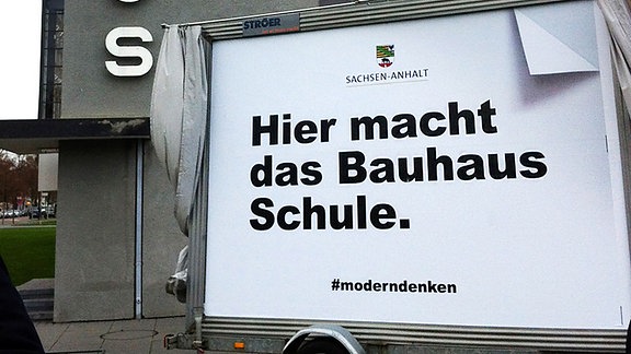 Ein Plakat mit der Aufschrift «Hier macht das Bauhaus Schule» ist am 06.12.2017 vor dem Bauhaus Dessau in Dessau-Roßlau (Sachsen-Anhalt) zu sehen.