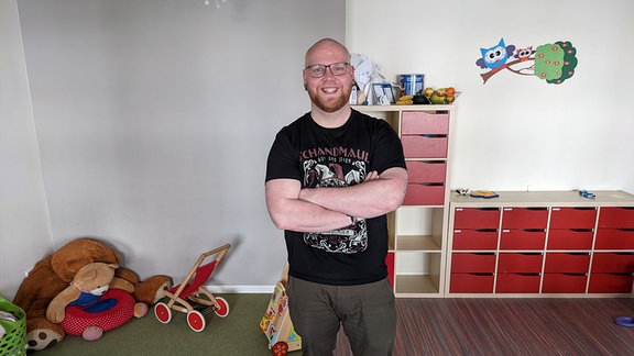 Ein glatzköpfiger Mann in einem Raum mit Spielzeug