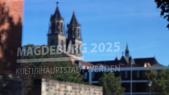 Der Magdeburger Dom spiegelt sich in einer Scheibe auf der Magdeburg 2025 steht. 