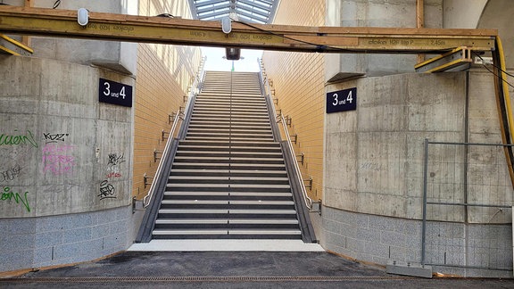 Ein betonierter Treppenaufgang zu Gleisen drei und vier