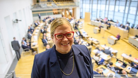 Maria Christina Rost steht im Landtag von Sachsen-Anhalt auf der Zuschauertribüne und lacht. 