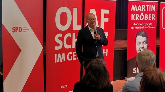 Olaf Scholz steht vor SPD-Bannern im Moritzhof.