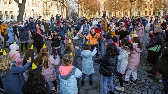 Teilnehmerinnen eines Tanz-Flashmops tanzen auf dem Domplatz von Magdeburg.