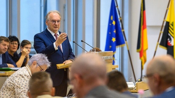 Reiner Haseloff steht im Plenarsaal des Landtages von Sachsen-Anhalt am Rednerpult