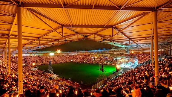 Ein Stadion mit vollen Tribünen und unzähligen Kerzen