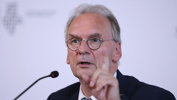 Reiner Haseloff (CDU, l), Ministerpräsident von Sachsen-Anhalt, spricht während einer Pressekonferenz