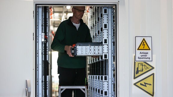 Ein Mitarbeiter der Tesvolt GmbH montiert die APU (Active Power Unit) in einem 40Fuss-Container, der als 4MWh Batteriespeicher für einen Solarpark gedacht ist.