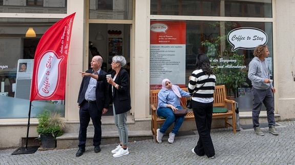 Fünf Personen stehen vor einem Schaufenster