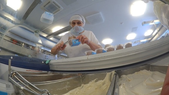 Eine Mitarbeiterin der Florida-Eis-Manufaktur in Staaken füllt Dosen mit frischem Eis.