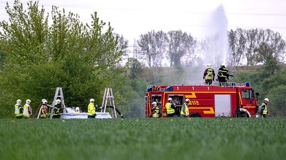 insatzkräfte der Feuerwehr kühlen mit Löschwasser das Umfeld einer Erdgaskaverne während einer Notfallübung in Peißen bei Bernburg. 