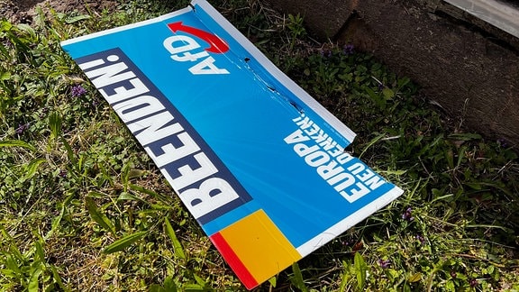 Ein Teil eines AfD-Wahlplakates liegt auf dem Boden. 