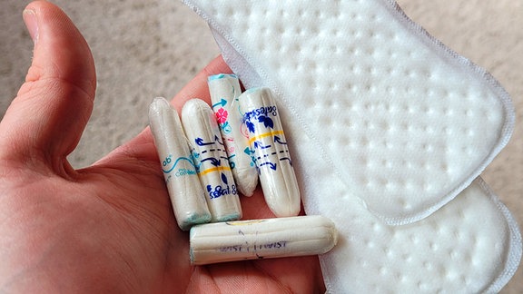 Binden und Tampons auf einer Handfläche