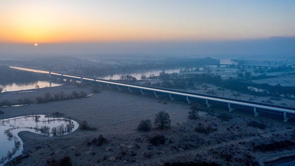 Die Sonne geht am Wasserstraßenkreuz Magdeburg auf. An dieser Stelle führt der Mittellandkanal in der Trogbrücke über die Elbe. Sie ist mit einer Gesamtlänge von 918 Metern die größte Kanalbrücke Europas. (Luftaufnahme mit Drohne)