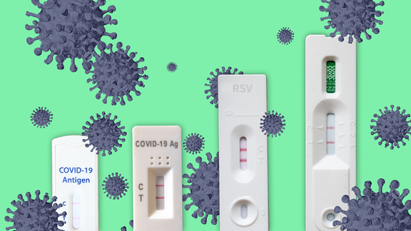 Vier Corona-Tests. Drum herum sind einzelne Modelle des Coronavirus angeordnet.