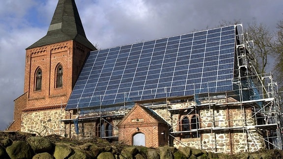 Zernin (Mecklenburg-Vorpommern): Die unter Denkmalschutz stehende Dorfkirche aus dem 13. Jahrhundert in Zernin (Landkreis Güstrow) trägt nach ihrer Wiedereinweihung am 03.02.2002 auf der südlichen Dachhälfte eine Photovoltaik-Anlage.