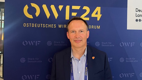 Matthias Bonkaß, Vice President Global foundries Dresden, steht vor einer blauen Wand.