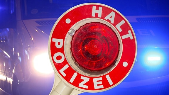 Eine Nahaufnahme einer Polizeikelle mit der Aufschrift HALT POLIZEI.