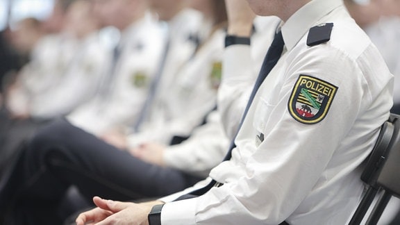 Absolventinnen und Absolventen der Fachhochschule Polizei sitzen zur Zeugnisausgabe im Ballhaus Aschersleben. 