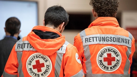 Zwei Rettungssanitäter in einer Rettungswache des Deutschen Roten Kreuzes (DRK).