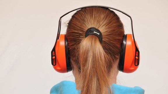 Ein Mädchen trägt Schallschutzkopfhörer. 
